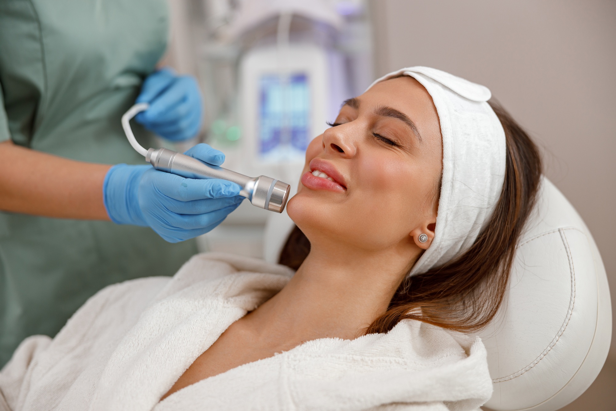 Potrait of female client getting aesthetic face treatment in beauty salon