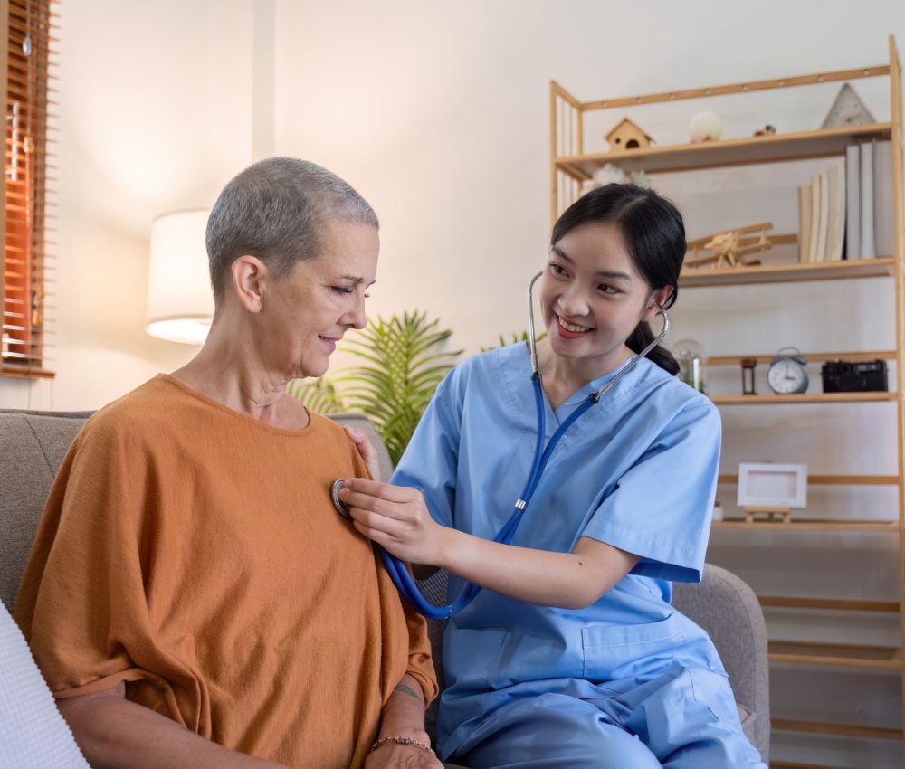 Elderly Caregiver Conducting Health Check on Elderly Woman at Home for Senior Healthcare and