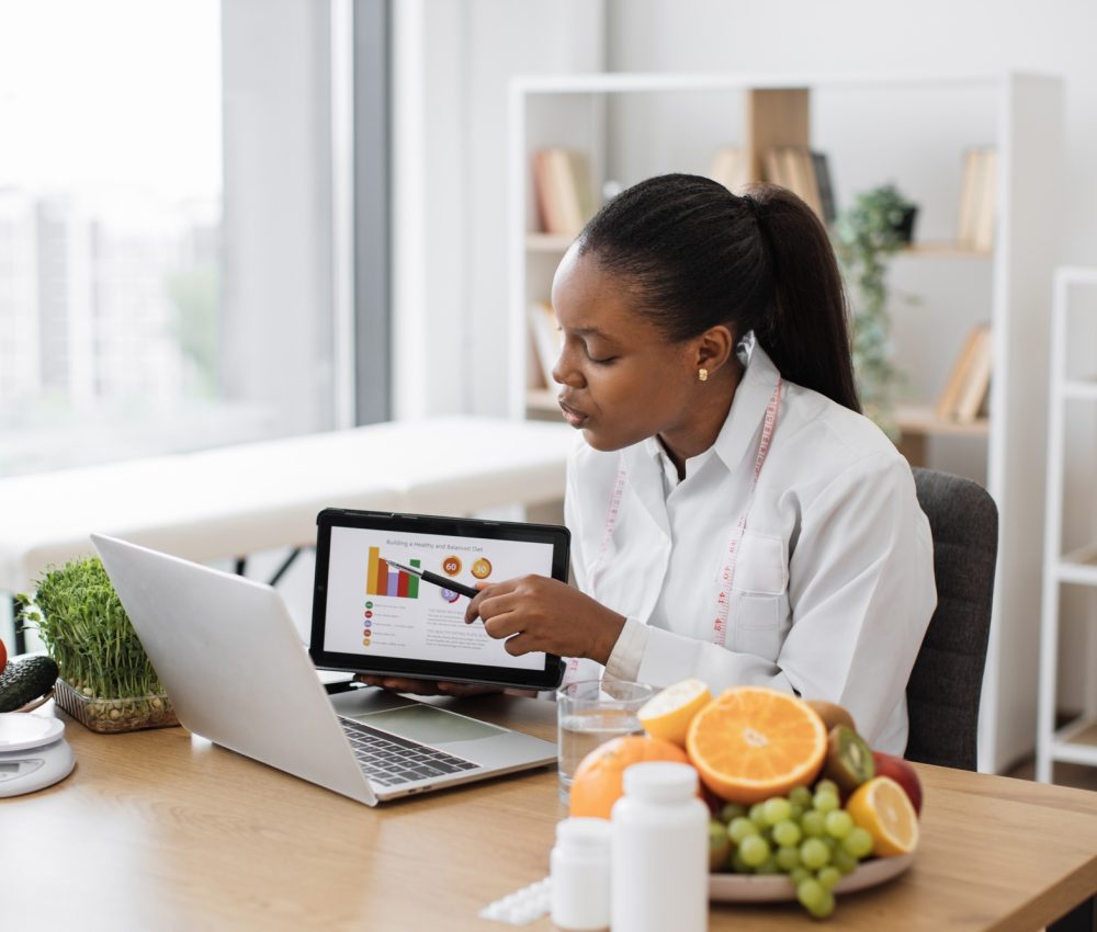 Expert with meal plan on tablet meeting with client online