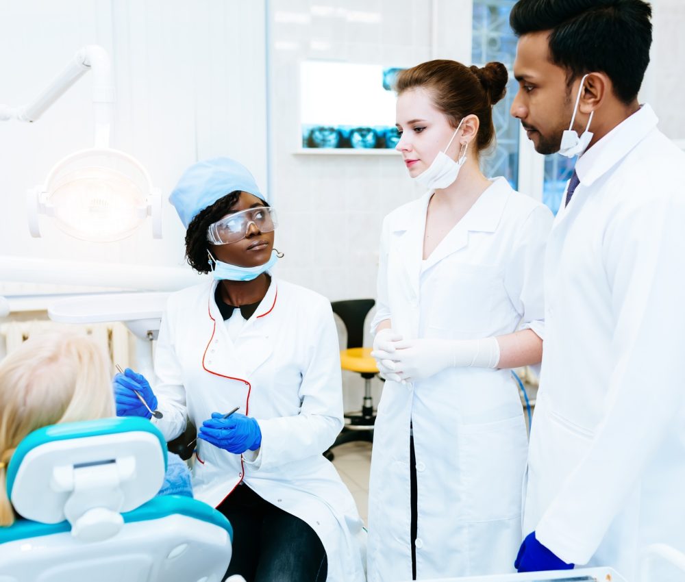Multiracial dental team with patient in dental clinic. Dental health concept