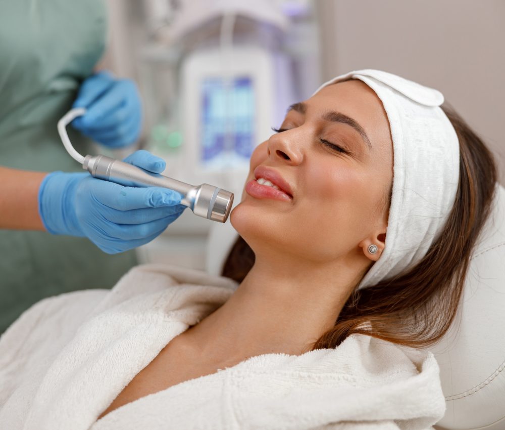 Potrait of female client getting aesthetic face treatment in beauty salon